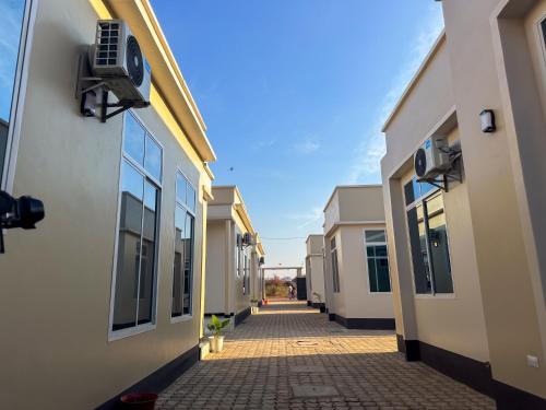 an empty alley between two buildings with a blue sky at Cool Stay Apartments Dodoma in Dodoma