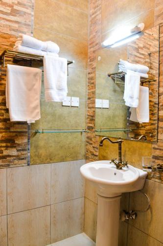 a bathroom with a sink and a mirror and towels at Decale Jewel Stone Hotel in Nairobi