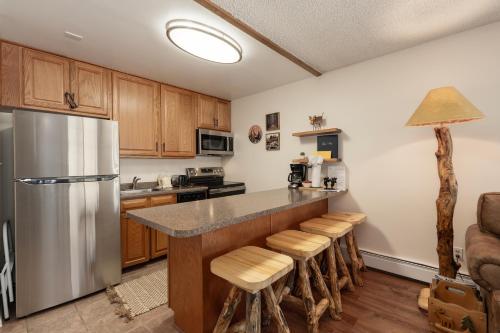 a kitchen with a stainless steel refrigerator and wooden cabinets at Hi Country Haus Unit 1515 in Winter Park