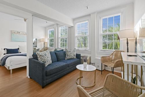 a living room with a blue couch and a bed at Tropicals of Palm Beach in Palm Beach