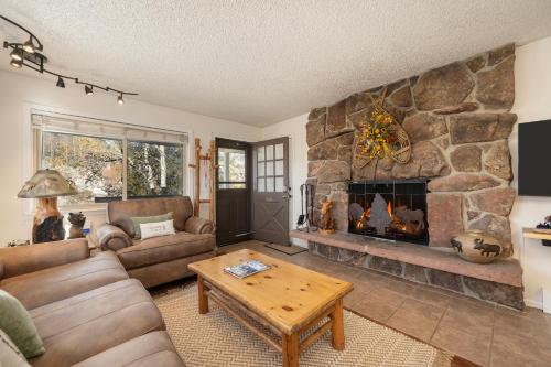 a living room with a large stone fireplace at Hi Country Haus Unit 1515 in Winter Park