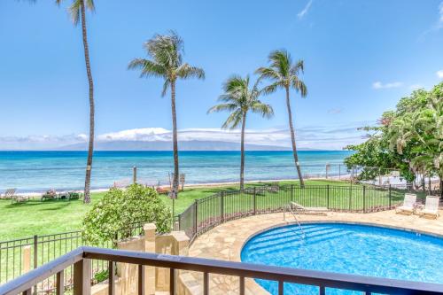 Una vista de la playa desde el balcón de un resort. en Paki Maui 122, en Honokowai