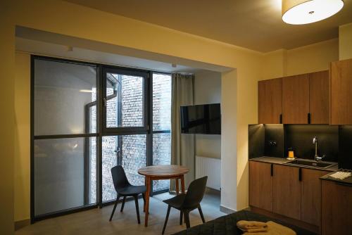 a room with a table and chairs and a window at Aparthotel CENTRUM Wrocławska 13 in Bytom