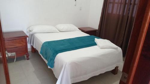 - une chambre avec un lit blanc et une couverture bleue dans l'établissement Villa Cristina en Villas Camino Real cerca de las dunas de Chachalacas, à Ursulo Galván