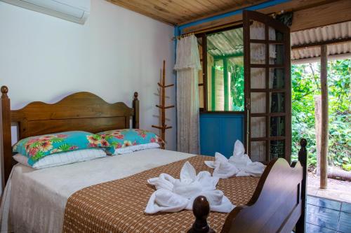 a bedroom with a bed with towels on it at Pousada Canto da Sereia in Ilha do Mel