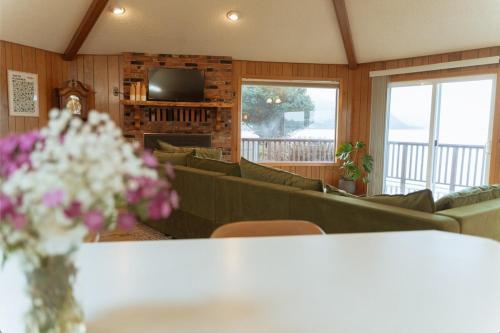 a living room with couches and a table with flowers at Whiskey Creek Retreat in Tillamook
