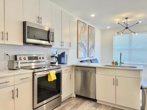 a kitchen with white cabinets and stainless steel appliances at Modern 1-Bedroom Condo in Downtown Atlanta 525Pkwy517 in Atlanta