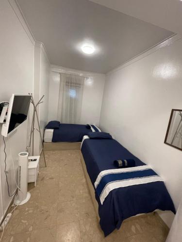 a bedroom with two beds and a flat screen tv at New in Loures in Lisbon