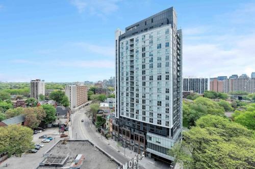 a tall glass building on a city street at City Lights Studio w Balcony Walk to Eaton Centre in Toronto