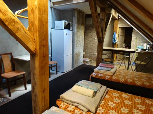 a room with three beds and a white refrigerator at Riia 141 Apartment in Pärnu