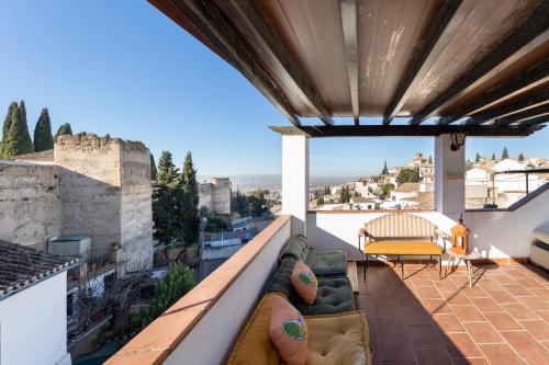 a patio with a couch and a table on a balcony at Apartamentos - PinkSparrow - in Granada