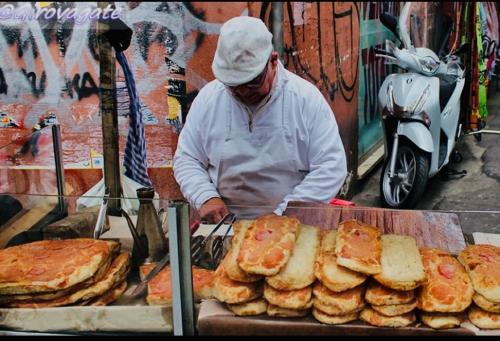 a man is preparing food on a table with bread at Luna di Sicilia in Palermo