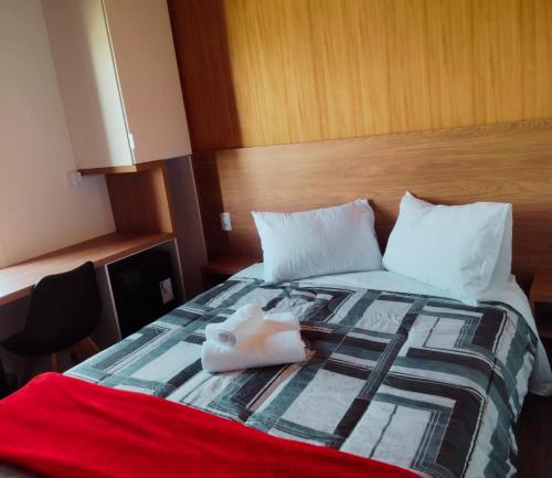 a hotel room with a bed with a towel on it at São Francisco de Paula - Quarto Confortável na Serra! in São Francisco de Paula
