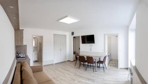 una sala de estar con un sofá, una mesa y sillas en HunGasthaus 01, en Mariazell