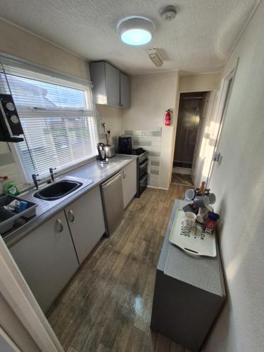 a small kitchen with a sink and a table in it at Chalet 81 South Shore Bridlington 2x Bedroom Detached Chalet Sleeps 4 in Bessingby