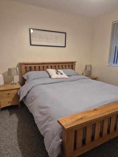 a bedroom with a large wooden bed and two lamps at Bobbi's Bothy in Newcastle