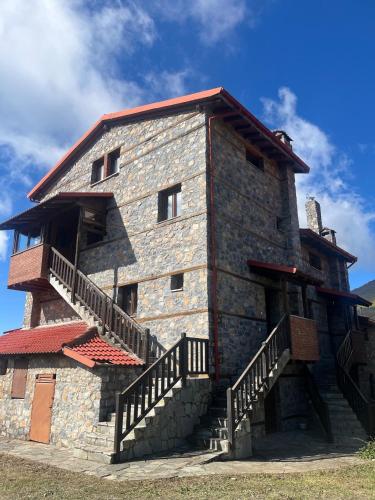 a large stone building with stairs on the side of it at Aelios Petra in Palaios Agios Athanasios