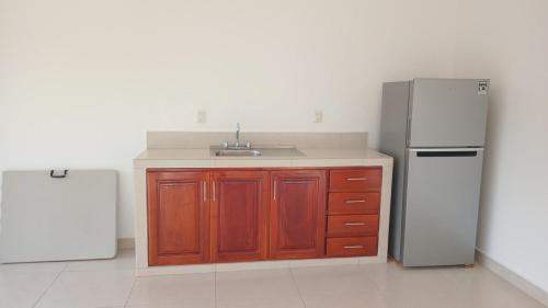 une cuisine avec un évier et un réfrigérateur dans l'établissement Villa Josefa en Villas Camino Real cerca de las dunas de Chachalacas, à Ursulo Galván