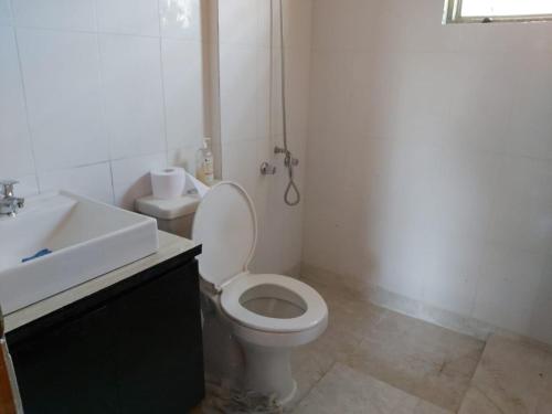 a bathroom with a white toilet and a sink at Casa sector Vista Hermosa primera linea in Chacurra