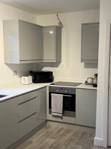 a kitchen with stainless steel appliances and white cabinets at 2 Bed Worksop Home in Worksop