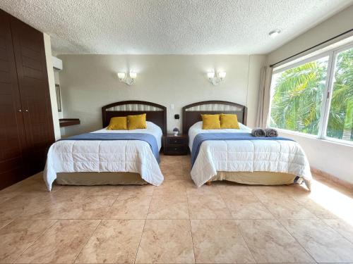 a bedroom with two beds with yellow pillows at Incredible apartment condominio with BEACH in Cancún