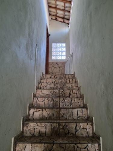 a staircase in an old building with a window at Aconchego Paraíso 2 Shopping com Garagem e Suíte in São João del Rei