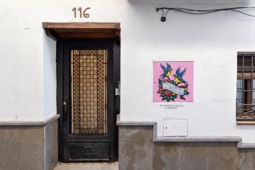 a door to a building with a painting on it at Apartamentos - PinkSparrow - in Granada