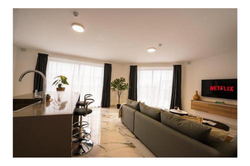 a living room with a couch and a table at Exclusive Corner Penthouse with Terrace - by HostMT in St. Paul's Bay