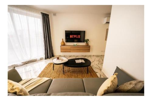 a living room with a couch and a tv at Exclusive Corner Penthouse with Terrace - by HostMT in St. Paul's Bay