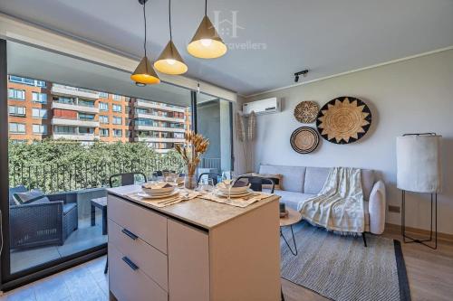 a kitchen and living room with a couch and a table at HT A pasos de Alto Las Condes con Estacionamiento in Santiago
