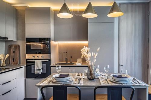 a kitchen with a table with plates and glasses on it at HT A pasos de Alto Las Condes con Estacionamiento in Santiago