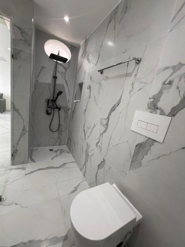 a bathroom with a toilet and a marble wall at Boca Beach 504, Boca Chica in Boca Chica