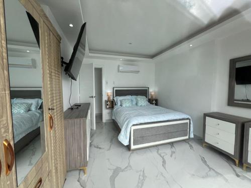 a bedroom with a bed and a flat screen tv at Boca Beach 504, Boca Chica in Boca Chica