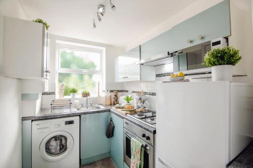 a kitchen with a washing machine and a refrigerator at Central Sheffield Stadium House 15ppl Free Parking in Sheffield