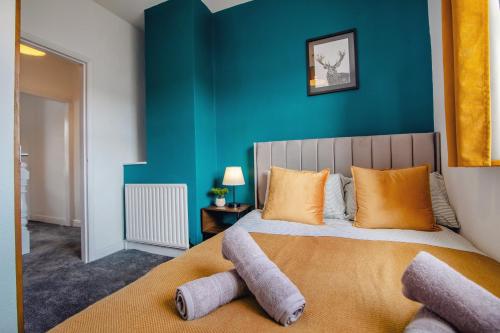 ein Schlafzimmer mit einem Bett mit einer blauen Wand in der Unterkunft Central Sheffield Stadium House 15ppl Free Parking in Sheffield