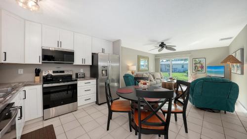 una cucina e una sala da pranzo con tavolo e sedie di New, New, NEW!, 3 Pools, Right on Siesta Beach! a Siesta Key