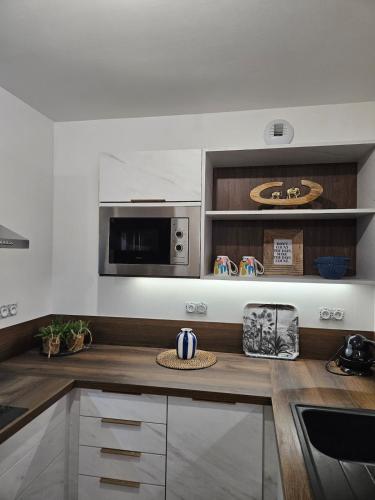 una cucina con piano di lavoro e forno a microonde di Les Volets Bleus house and spa a Jublains