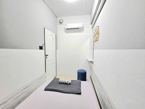 une petite chambre avec un banc et une porte dans l'établissement Future Hostel Pattaya, à Nong Prue