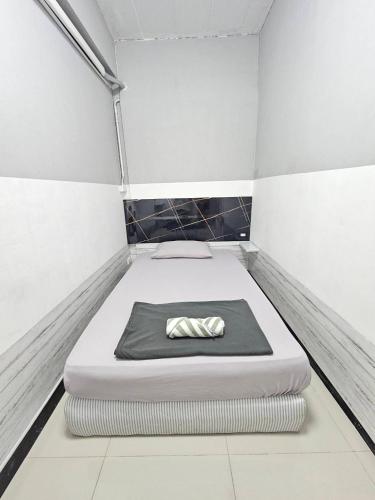 a small room with a bed with a pillow on it at Future Hostel Pattaya in Nong Prue