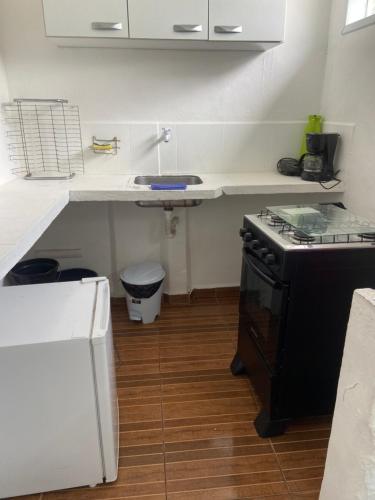 a kitchen with a stove and a counter top at Antonia Hospedaria 1 in Búzios