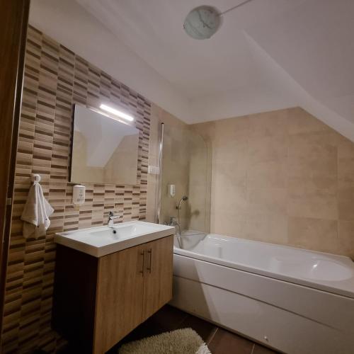 a bathroom with a white tub and a sink and a bath tub at Rupicapra Holiday Mountain House in Kostel
