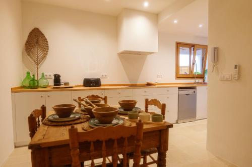 a kitchen with a wooden table with bowls on it at Ca La Portella in Jávea