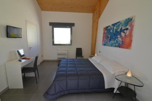 a bedroom with a blue bed and a desk at Masseria La Meridiana in Altamura