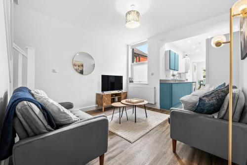a living room with two gray couches and a table at Coventry Arena Escape in Longford