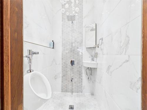 a bathroom with a toilet and a sink and a urinal at Playoff Stay Wrigley 4br Garage Firepit Patio in Chicago