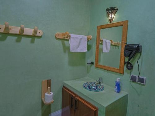 Un baño con lavabo, espejo y toallas. en Imlil Oasis -Oasis D'imlil -, en Imlil