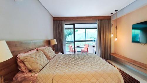 a hotel room with a bed and a television at Studio no Eco Resort Praia dos Carneiros - Serviços de Limpeza Diária in Tamandaré