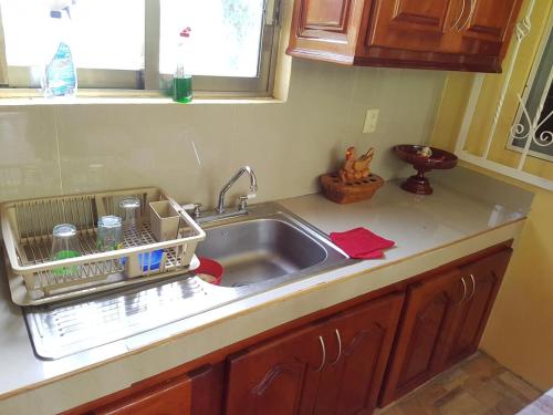 un évier de cuisine avec un égouttoir à vaisselle à côté dans l'établissement Villa El Lago en Villas Camino Real cerca de las dunas de Chachalacas, à Ursulo Galván