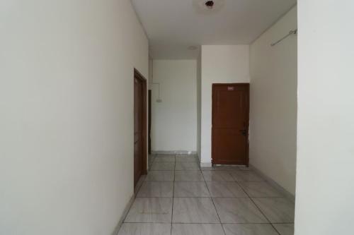 an empty hallway with a door and a tile floor at SPOT ON Sneha Home Stay in Dehradun
