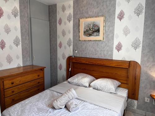 Lys des Pyrénées في آكس ليه تيرم: غرفة نوم مع سرير مع اللوح الأمامي الخشبي